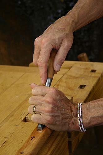 John's hands carving and shaping a Native American Style flute.